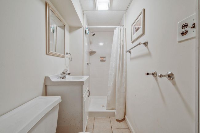 Full bath featuring tile patterned floors, a tile shower, and vanity | Image 23