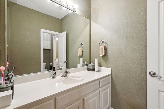 Bathroom featuring a textured wall and vanity | Image 19