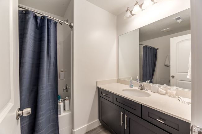 Full bathroom with shower / bath combo, visible vents, baseboards, and vanity | Image 16