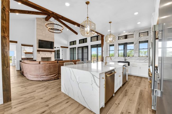 Kitchen with beamed ceiling, light wood-style flooring, white cabinets, high vaulted ceiling, and stainless steel dishwasher | Image 9