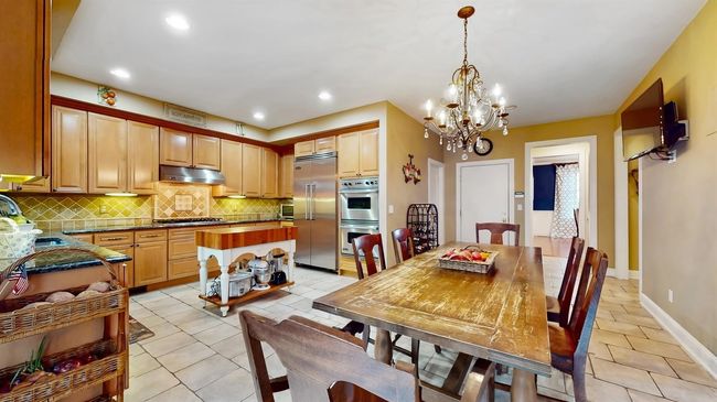 Dining area featuring light tile patterned floors, a chandelier, and recessed lighting | Image 5