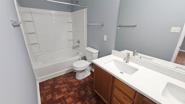 Full bathroom featuring double vanity, shower / bath combination, and a textured wall | Image 7