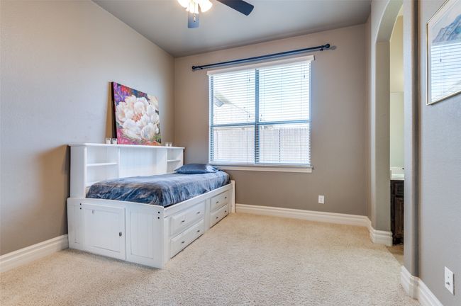Bedroom featuring light carpet, ceiling fan, arched walkways, and baseboards | Image 30