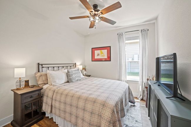 Bedroom featuring ceiling fan, baseboards, and wood finished floors | Image 27
