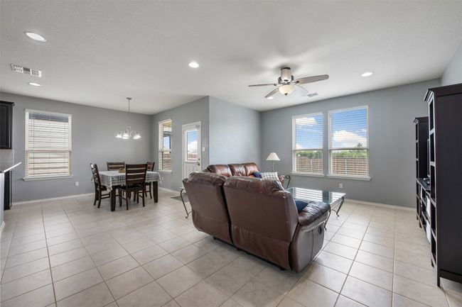 Living area with recessed lighting, visible vents, and ceiling fan with notable chandelier | Image 12