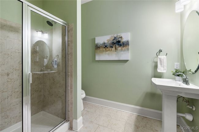 First floor full bathroom, tile shower stall, tile flooring, pedestal sink, toilet. | Image 19