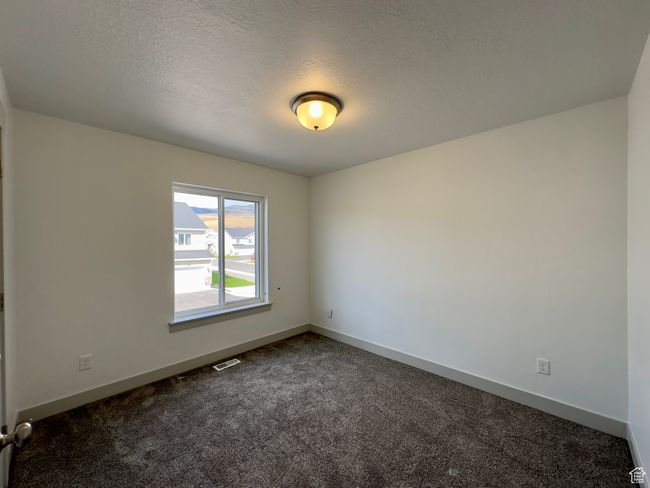 Bedroom with carpet and a textured ceiling | Image 13