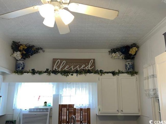 Detailed view of crown molding and ceiling fan | Image 4