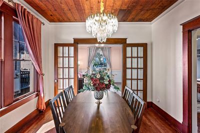 Original hardwood floors and shiplap ceiling with a glistening chandelier in this beautiful dining room! | Image 3