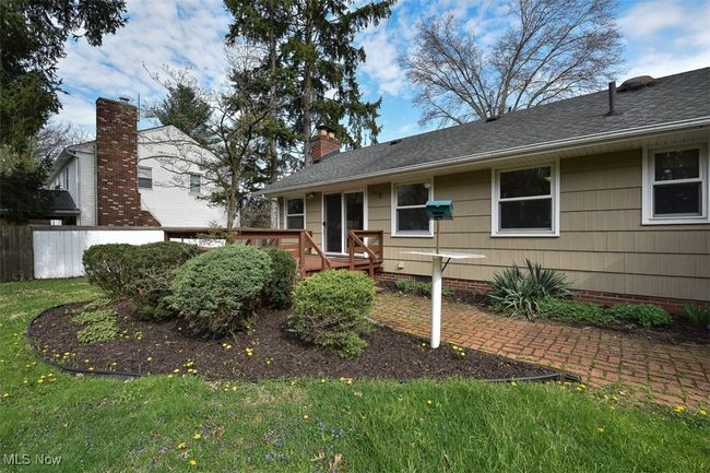 Ranch-style house featuring a chimney, fence, a front lawn, roof with shingles, and a deck | Image 5