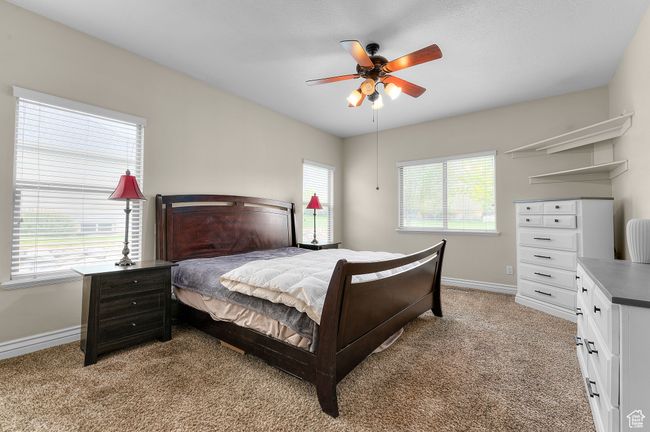 Bedroom featuring ceiling fan, light colored carpet, and baseboards | Image 8