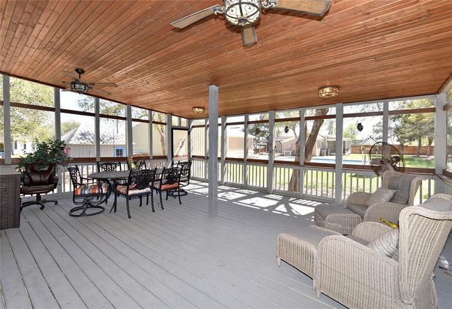 The screened in porch on the Main house has room for the whole family at the same time. Watch the kids swim from the comfort of the screened in porch. | Image 15