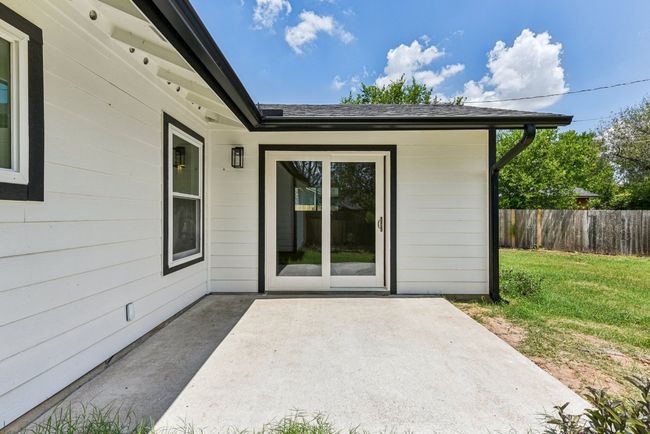 Doorway to property featuring a patio area and roof with shingles | Image 31