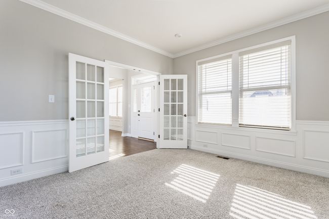 carpeted spare room with a decorative wall, wainscoting, french doors, ornamental molding, and visible vents | Image 10