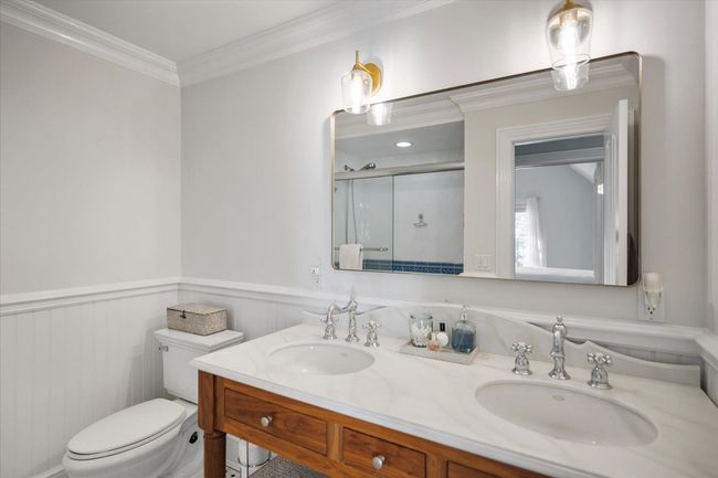 Bathroom with toilet, a sink, a wainscoted wall, and a stall shower | Image 27