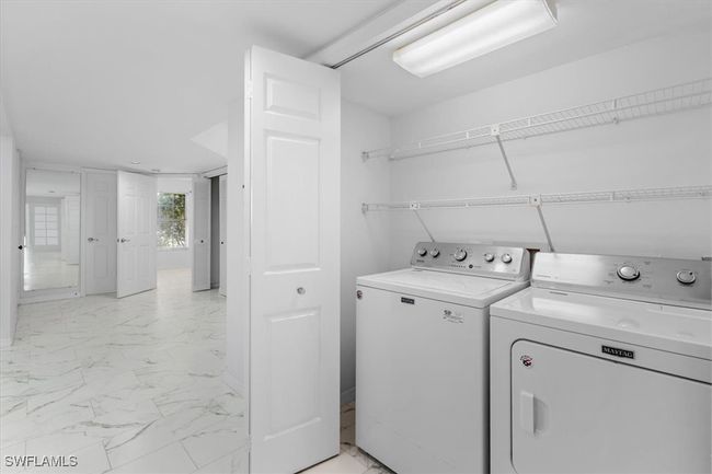 Clothes washing area with washer and clothes dryer and light tile patterned floors | Image 32