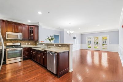 Bright condo with open floor plan &amp; gleaming hardwood floors. | Image 2