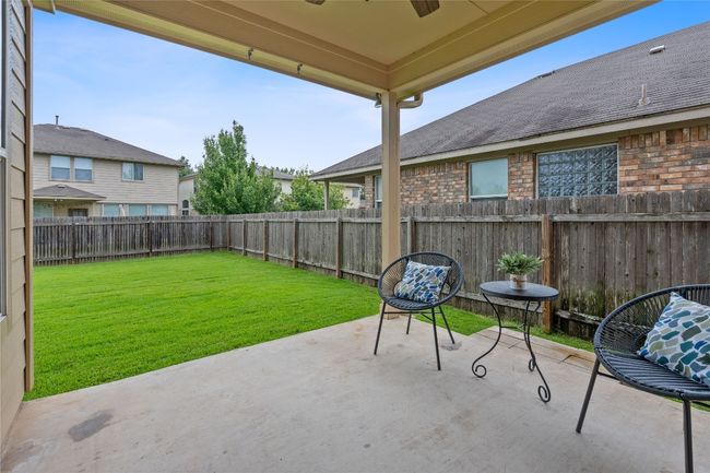 Fenced backyard with a ceiling fan and a patio area | Image 37
