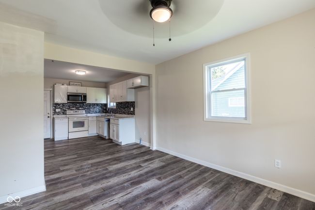 kitchen featuring electric stove, a ceiling fan, stainless steel microwave, tasteful backsplash, and dark wood-type flooring | Image 12