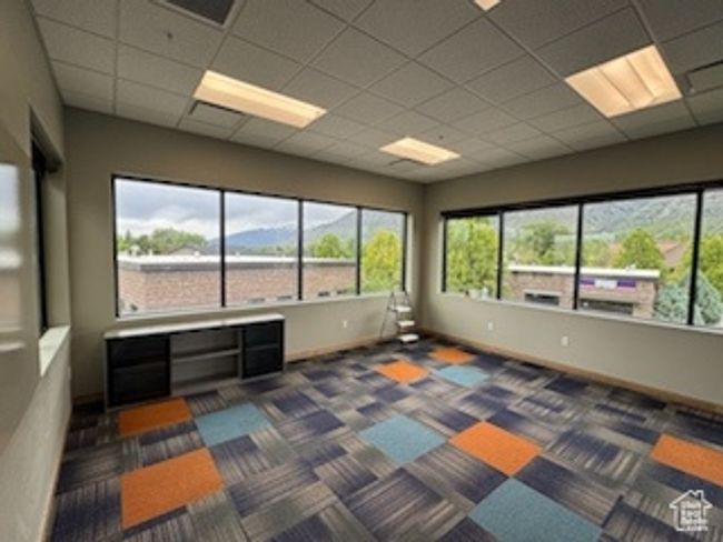 Spare room featuring healthy amount of natural light, a paneled ceiling, and dark colored carpet | Image 7
