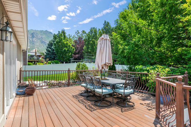 Wooden terrace featuring outdoor dining space, a mountain view, and a fenced backyard | Image 48