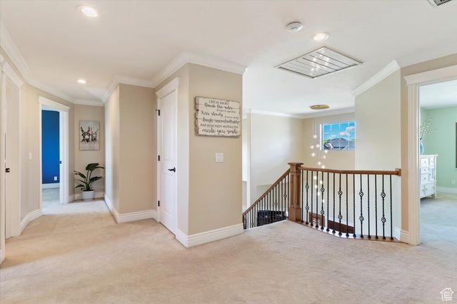 Hallway with carpet floors, baseboards, an upstairs landing, ornamental molding, and recessed lighting | Image 29