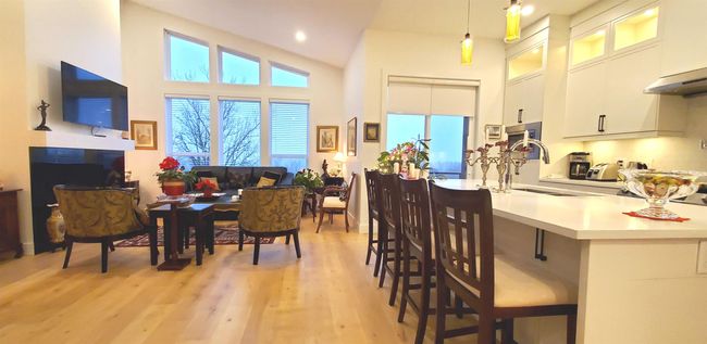 Kitchen featuring light countertops, light wood-type flooring, white cabinetry, and a towering ceiling | Image 22