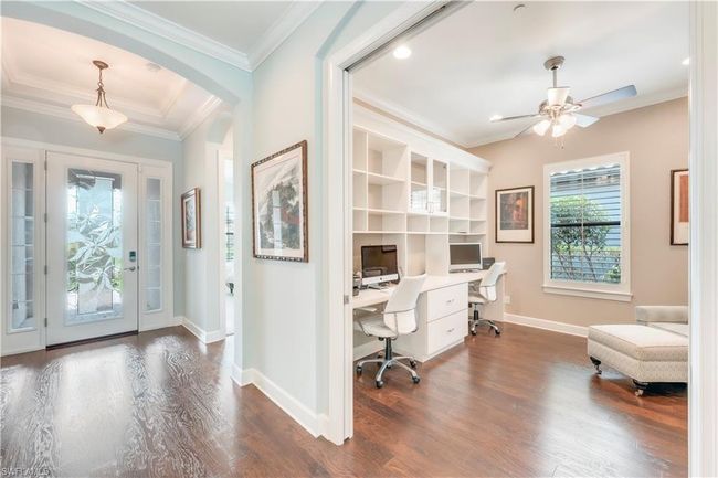 Entrance foyer with ceiling fan, dark wood-style flooring, ornamental molding, arched walkways, and baseboards | Image 16