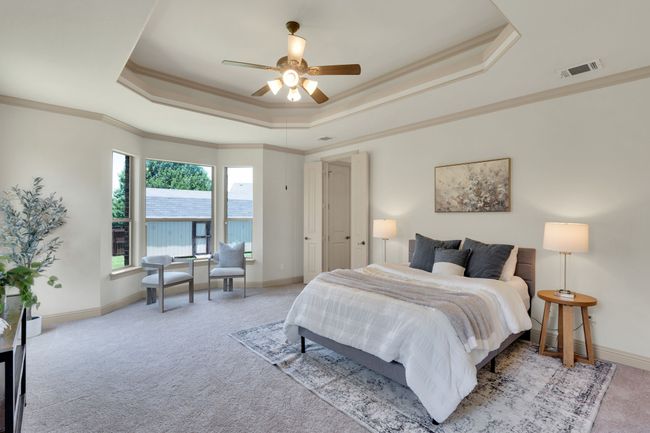Carpeted bedroom with a raised ceiling, ornamental molding, and a ceiling fan | Image 14