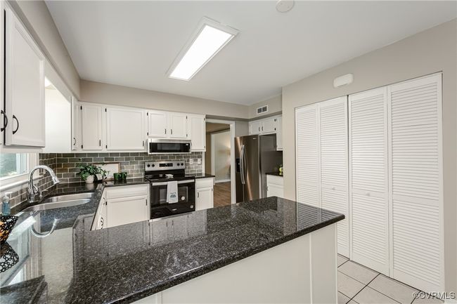 Kitchen featuring visible vents, a sink, tasteful backsplash, appliances with stainless steel finishes, and white cabinetry | Image 8