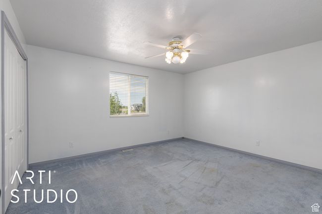 Carpeted spare room featuring ceiling fan and baseboards | Image 29