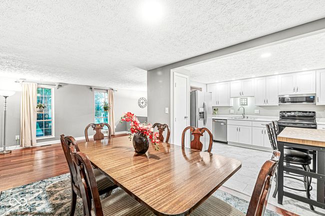 dining space featuring a textured ceiling and light wood-type flooring | Image 7
