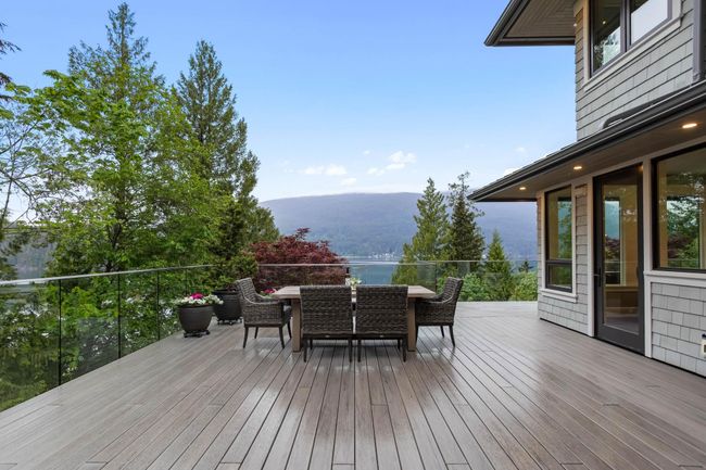 Wooden terrace featuring a mountain view and outdoor dining area | Image 32