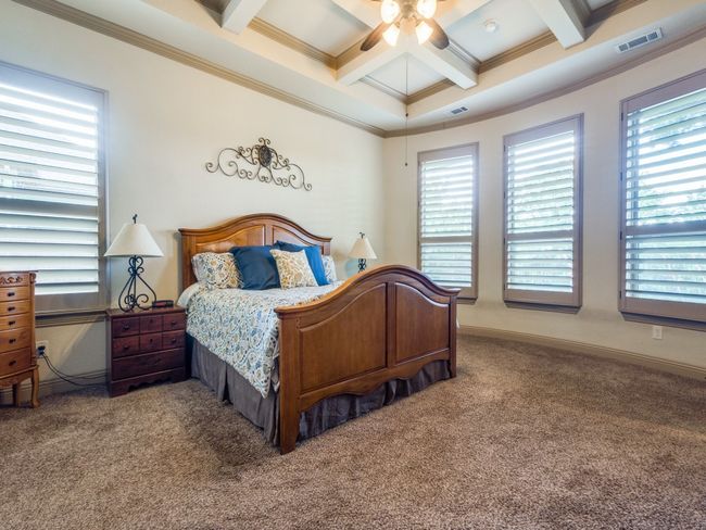 Carpeted bedroom with ornamental molding, coffered ceiling, beam ceiling, multiple windows, and baseboards | Image 14