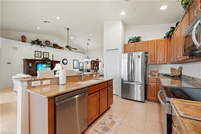 Kitchen with a sink, a kitchen island with sink, stainless steel appliances, and light tile patterned flooring | Image 16