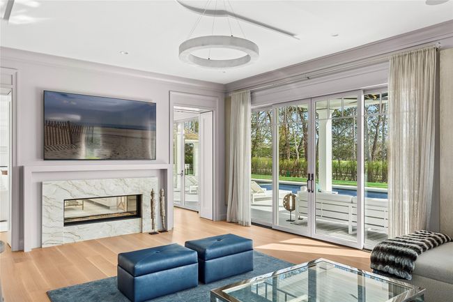 Living room with a fireplace and wood finished floors | Image 12