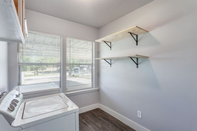 Clothes washing area with dark wood-style floors, independent washer and dryer, baseboards, and laundry area | Image 12