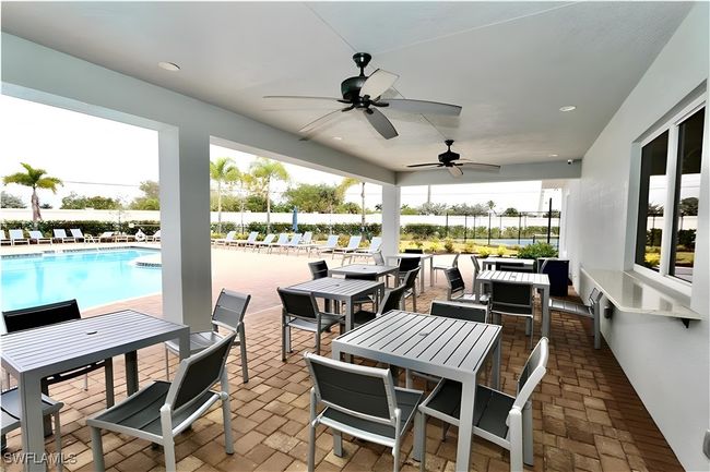 View of patio / terrace featuring outdoor dining space, a ceiling fan, a water view, and a community pool | Image 21