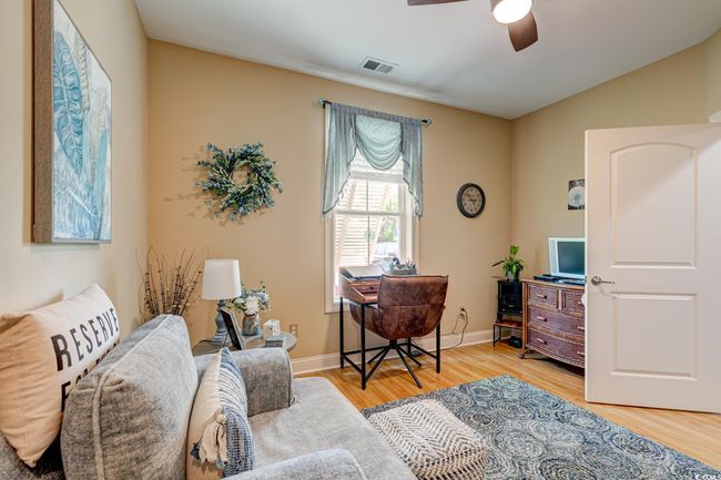 Sitting room with light wood-style flooring, visible vents, baseboards, and ceiling fan | Image 24