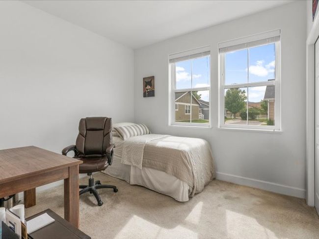 Bedroom featuring light carpet and an office area | Image 6