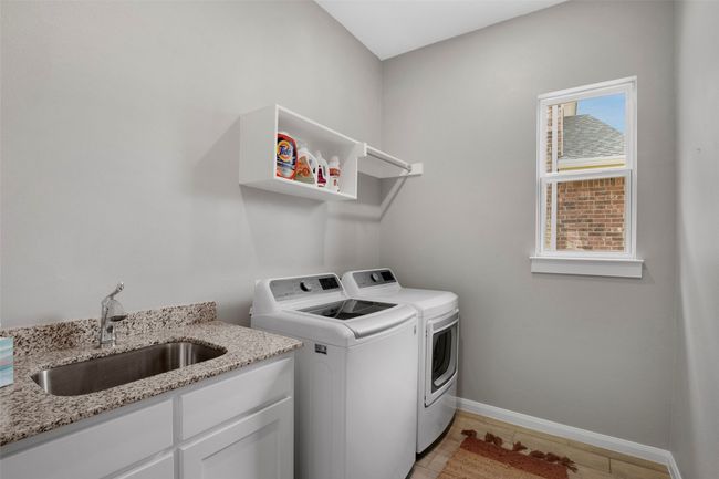 Washroom with a sink, washer and dryer, and baseboards | Image 11