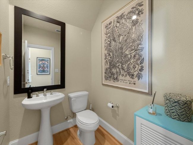 Bathroom with toilet, wood finished floors, baseboards, and a sink | Image 10