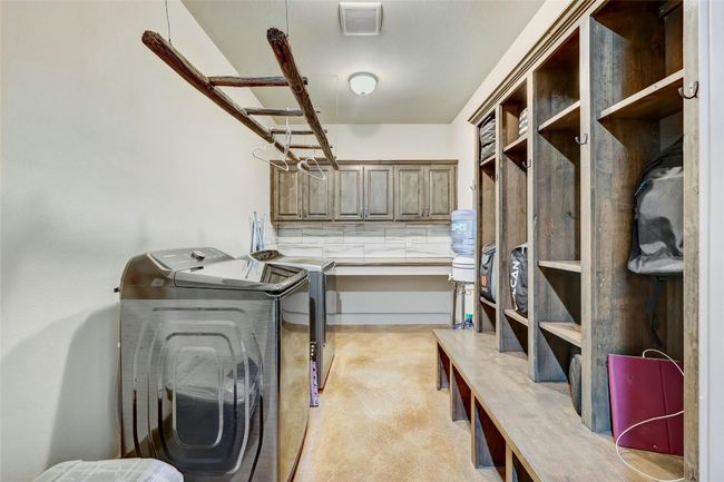 The multi-functional laundry and mud space has been well thought out. There is ample space to fold and dry laundry, room to store items for kids and pets, and even a charging station in each cubby. | Image 28