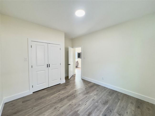 Unfurnished bedroom featuring baseboards, wood finished floors, and a closet | Image 13
