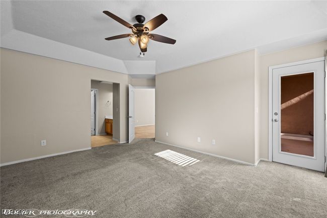Unfurnished bedroom featuring ensuite bathroom, baseboards, ceiling fan, and carpet flooring | Image 26