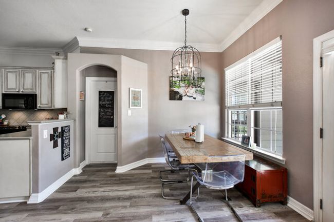 Dining space with a chandelier, ornamental molding, wood finished floors, and arched walkways | Image 8