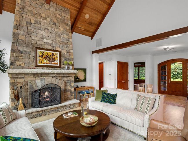 Floor to ceiling stone, natural gas log fireplace in main level living room. Room for ample seating. | Image 10