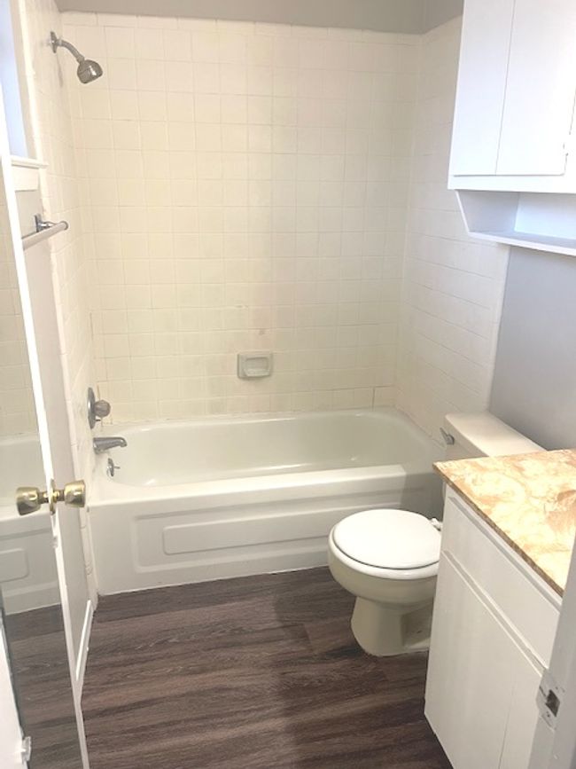Bathroom featuring wood finished floors, toilet, washtub / shower combination, and vanity | Image 7