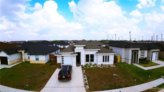 View of front of home with a garage, a front lawn, concrete driveway, and a residential view | Image 6