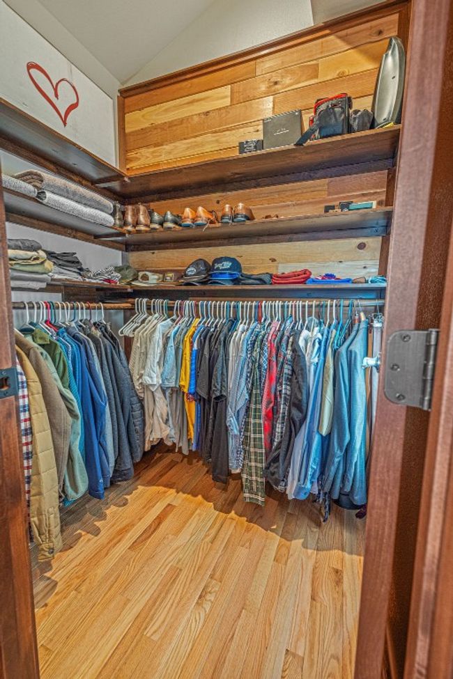 Walk in closet featuring lofted ceiling and wood finished floors | Image 24